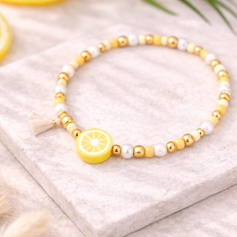 Perlenarmband in Gelb- und Weißtönen mit Zitronen Perle und goldenen Details auf hellem Stein – sommerliches DIY Armband aus Perlenarmband Set