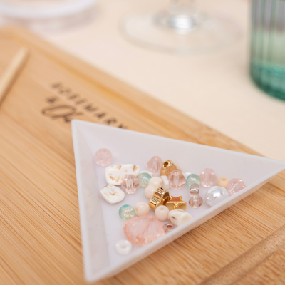 Verschiedene Perlen in einer weißen Perlenschale, nützlich für DIY Schmuck und Bastelarbeiten
