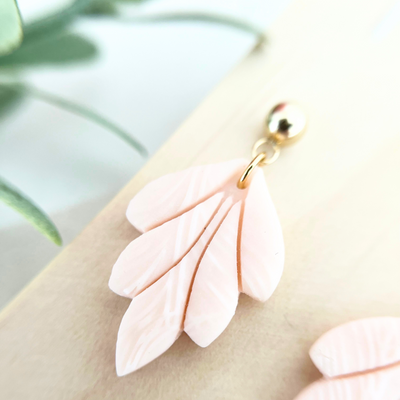 Detailaufnahme eines handgemachten Ohrrings TAORMINA in zartem Rosé mit eleganter Blattform, perfekt für empfindliche Haut und Allergiker