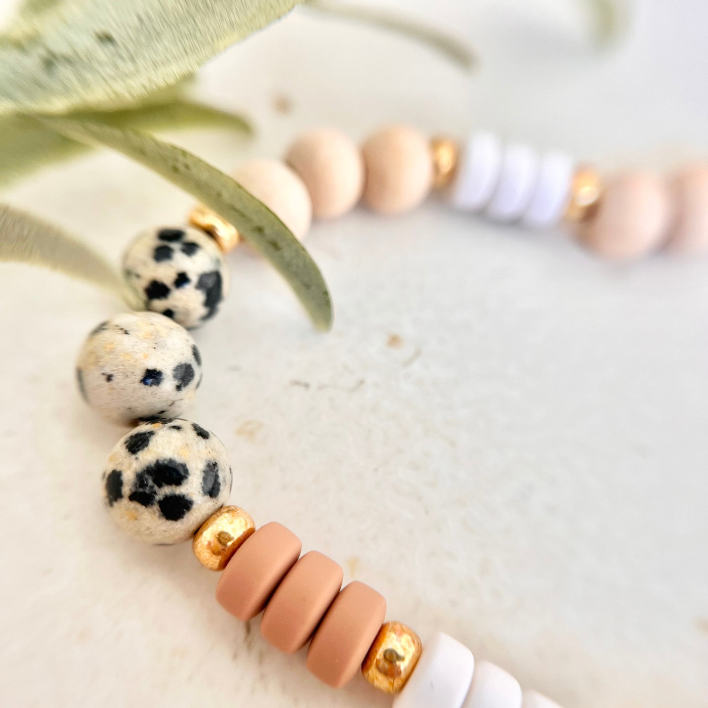 Detailaufnahme der Handykette SAVANA mit Dalmatiner-Perlen und beigen Acrylperlen als hochwertiges und dekoratives Handy Zubehör