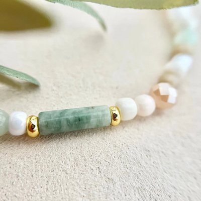 Detailaufnahme vom Armband – goldene Perlen und Muschelperlen mit schimmerndem Perlmutt-Charakter, personalisierbarer Gravur Anhänger für individuellen Schmuck