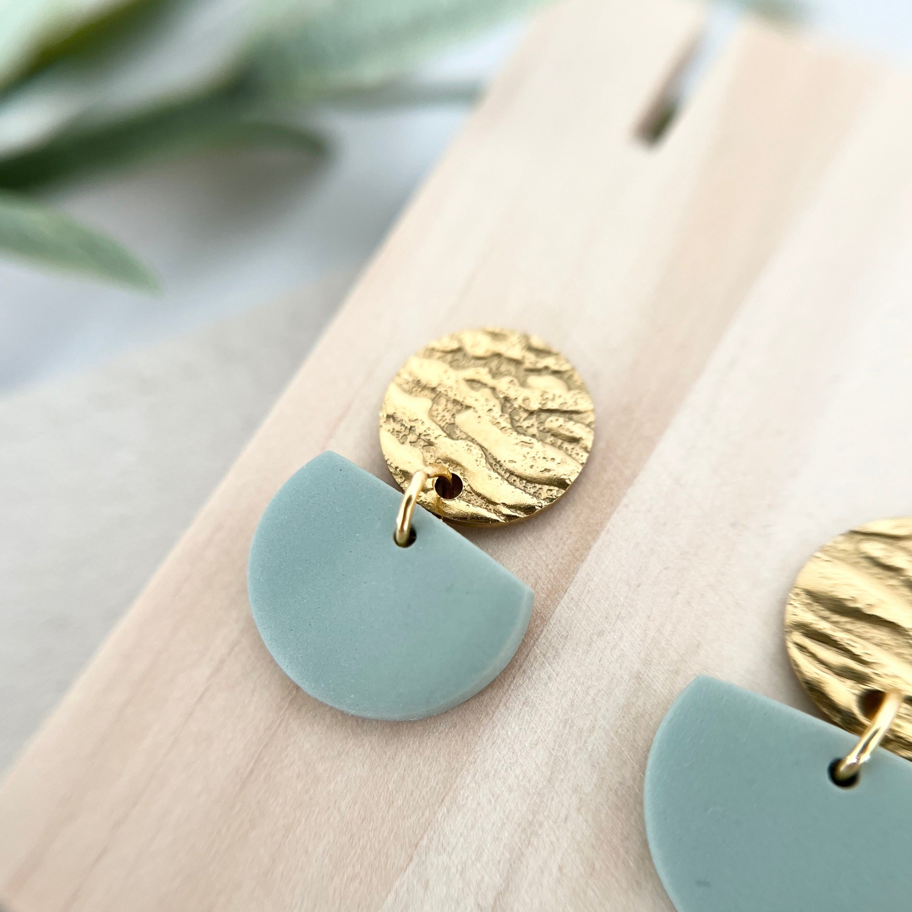 Nahaufnahme der Ohrringe ROSEMARY in sanften Grüntönen, kombiniert mit goldfarbenem Edelstahl für eine edle Struktur und ein minimalistisches Design