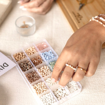 Hand greift nach Perlen aus dem DIY Kit – für individuell gestaltete Armbänder und Freundschaftsgeschenke.