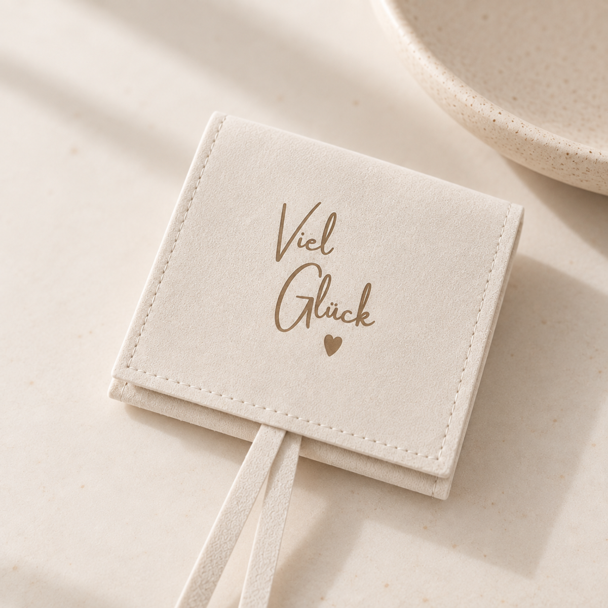 Heller Schmuckbeutel mit Aufschrift „Viel Glück“ und Herz – liebevolle Geschenkverpackung für Armbänder, Schmuck und kleine Glücksbringer.