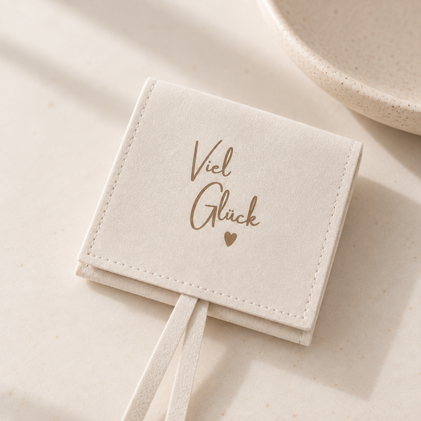 Heller Schmuckbeutel mit Aufschrift „Viel Glück“ und Herz – liebevolle Geschenkverpackung für Armbänder, Schmuck und kleine Glücksbringer.