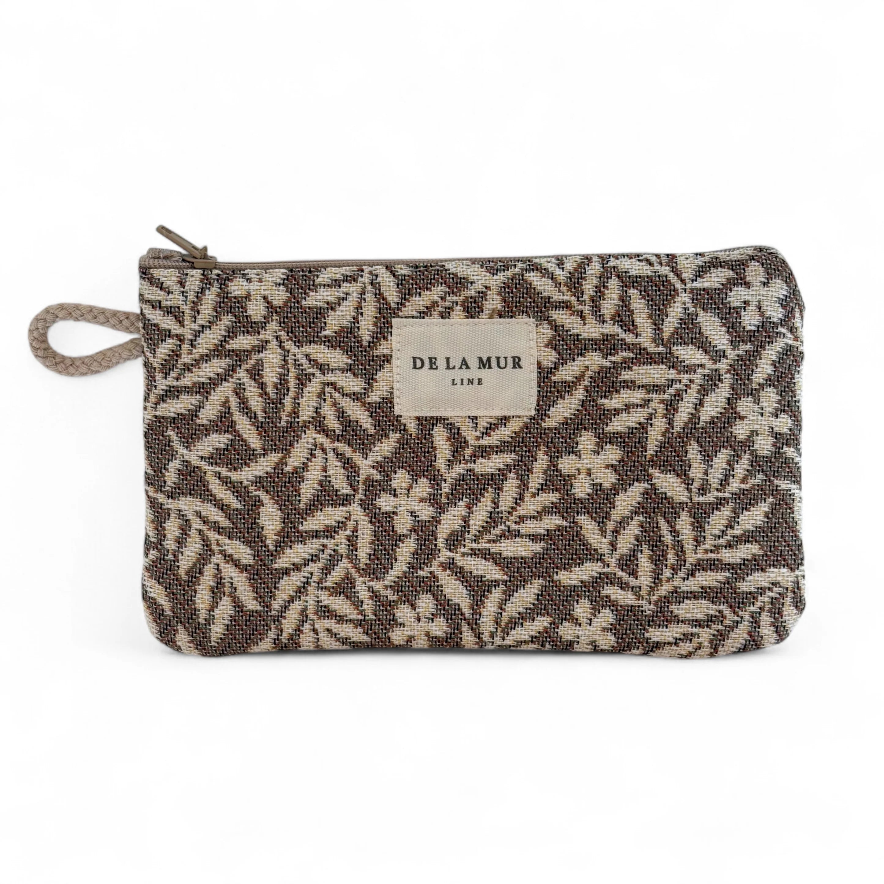 Rechteckige kleine Jacquard-Tasche von DE LA MUR mit cremefarbenem Blumenmuster auf braunem Hintergrund, Reißverschluss und seitlicher Kordelschlaufe. Die kleine Kosmetiktasche dient zur Aufbewahrung von Make-up, Pflegeartikeln oder Schmuck.