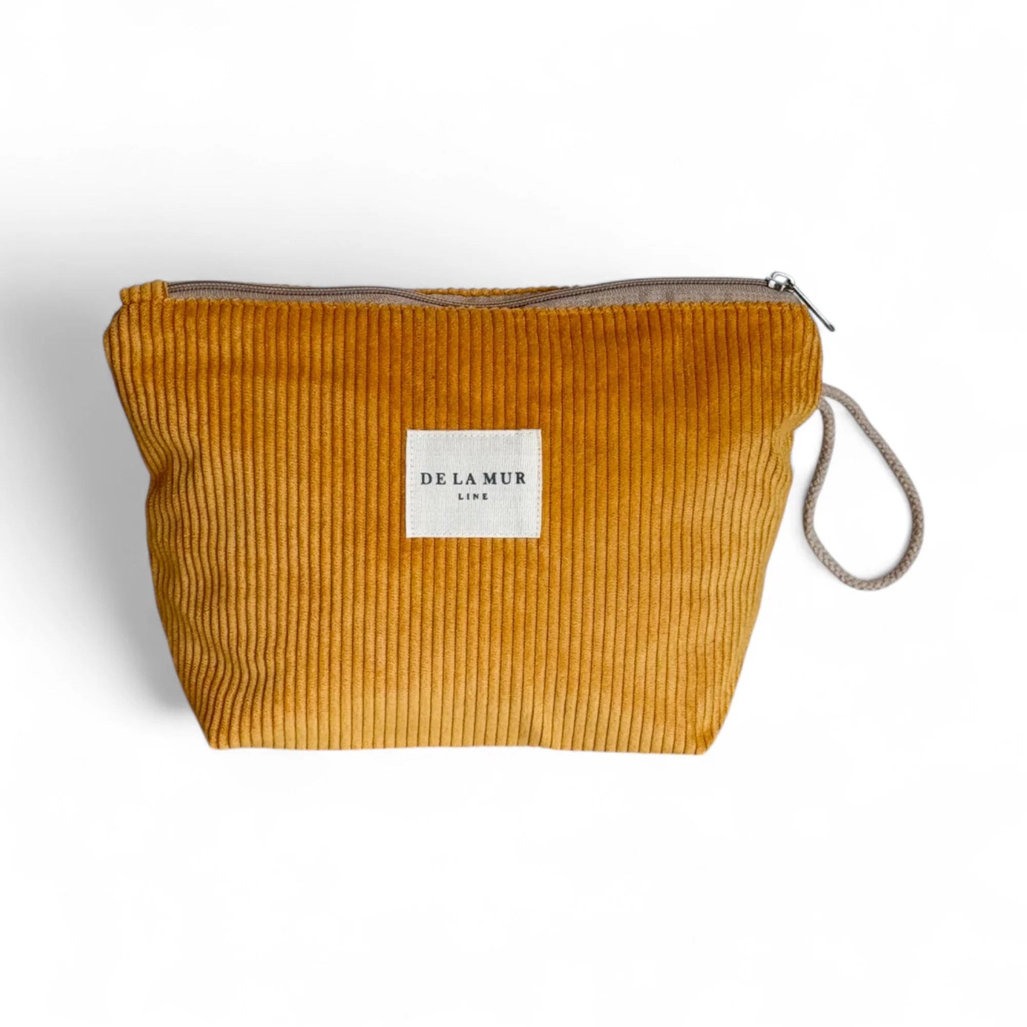 Große rechteckige Beauty Bag von DE LA MUR aus senfgelbem Cordstoff mit Rippenstruktur, Reißverschluss oben und seitlicher Kordelschlaufe. Handgefertigte Kosmetiktasche zur Aufbewahrung von Pflegeprodukten, Schmuck oder Reiseutensilien – inspiriert von warmen Sommertagen.