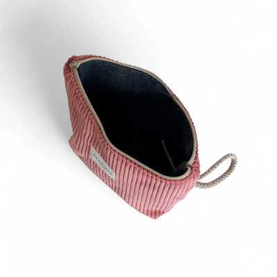 Nahaufnahme einer geöffneten, korallfarbenen Cord-Tasche. Die dunkle Innenfütterung und der graue Reißverschluss sind deutlich zu sehen. Die Tasche liegt auf weißem Hintergrund.