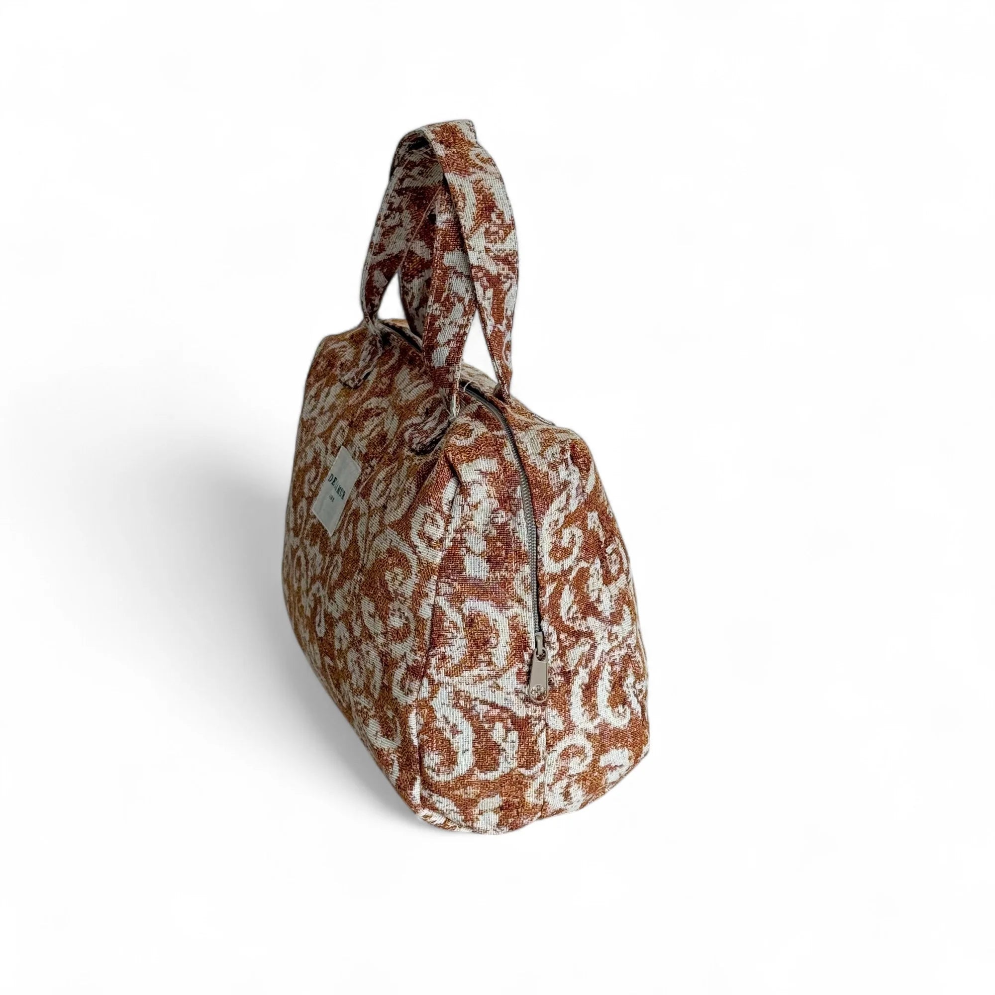 Elegante Beauty Bag von DE LA MUR aus feinem Jacquard mit warmen Terrakotta-Tönen – mediterranes Design trifft auf Handwerkskunst aus Barcelona.