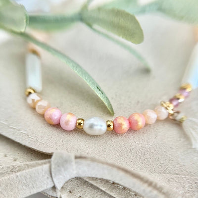 Detailaufnahme des Boho Perlenarmbands "Sommerträume" mit einer anderen Perspektive, die die Süßwasserperle und den Baumwollstoffanhänger zeigt