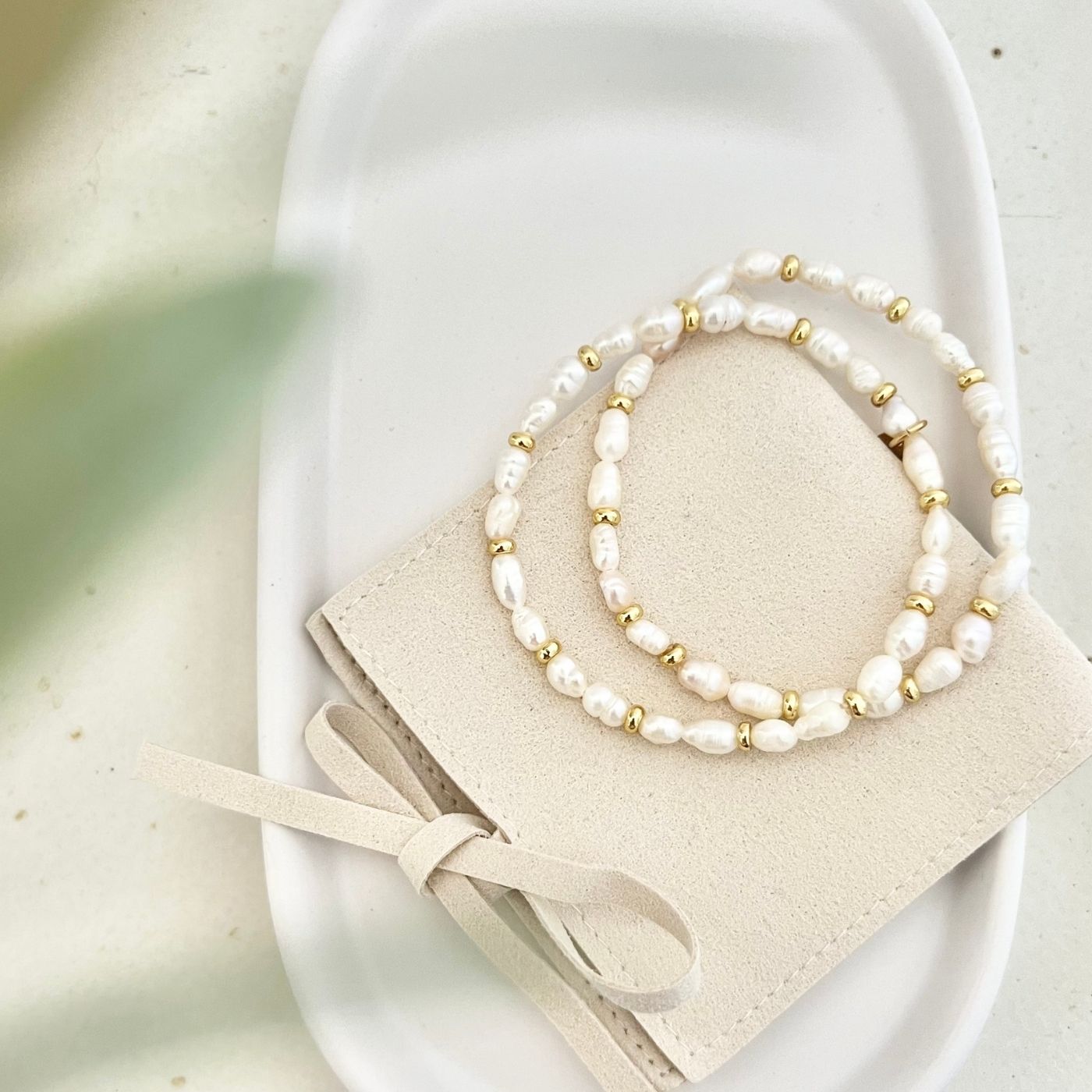 Vollansicht von zwei Armbändern ALVA ohne Anhänger, auf einer eleganten Tasche, perfekt für stilvolle Geschenkidee
