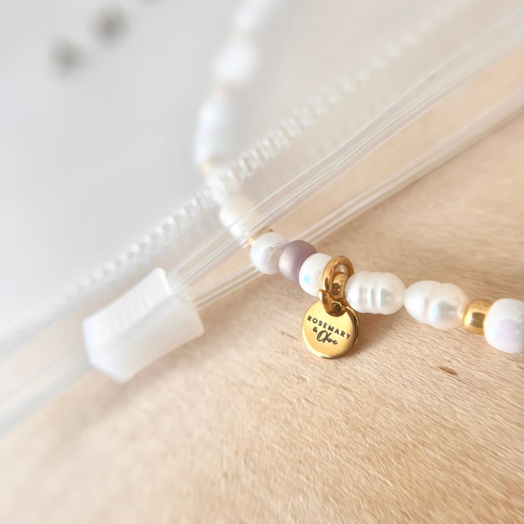Wasserfester transparenter Aufbewahrungsbeutel mit Reißverschluss, Nahaufnahme mit Perlenarmband und goldenem Anhänger, geeignet für Schmuckaufbewahrung auf Reisen oder am Strand
