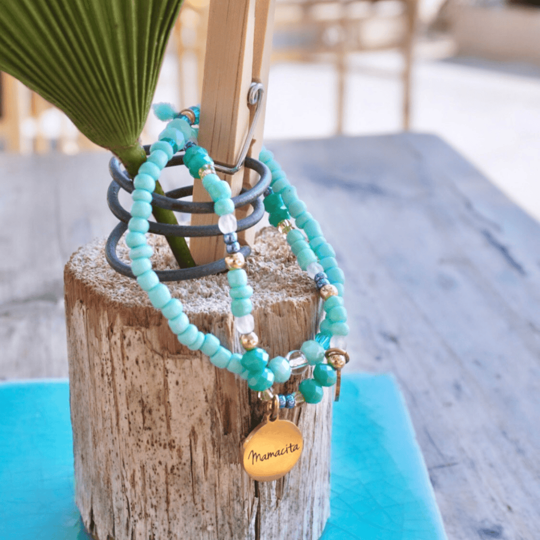 Kette mit graviertem Anhänger, drapiert auf einem Holzstück – personalisierter Schmuckanhänger.